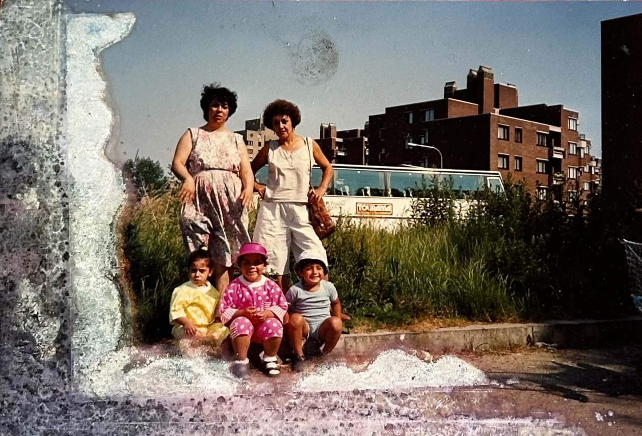 Photo de famille prise devant un bus, avec vue sur la cité-parc de Versailles, durant l’été des années 1980. Photographie issue de la collection de la famille Bustos et Casanova.